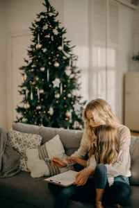 girl sitting on woman s lap while holding pen and paper, kerst in de narcistische familie