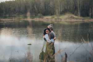 happy couple hugging near calm lake, eenzaamheid na complex trauma